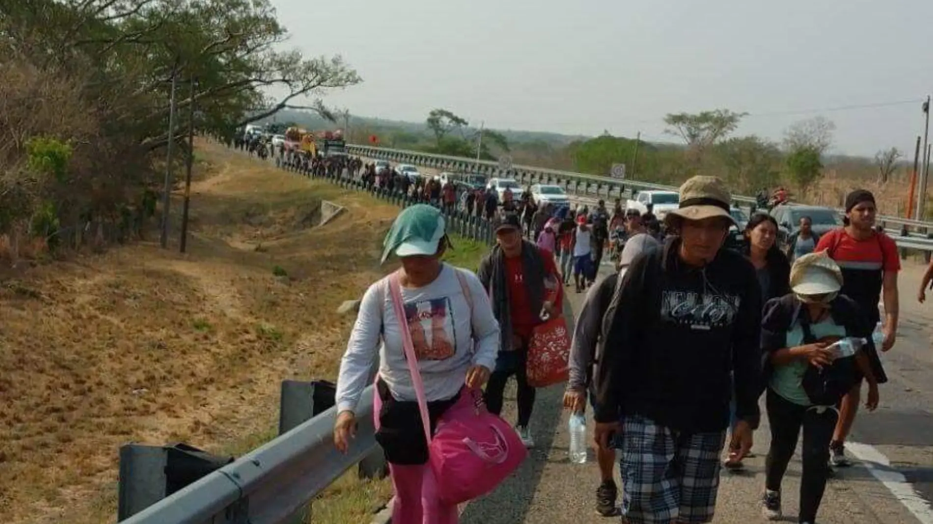 migrantes caminando en carretera